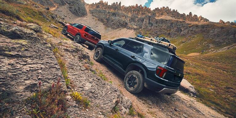 2027 Honda Passport TrailSport Elite in Smoke Blue Pearl back climbing a steep rocky mountain trail (Mid-Size SUV).